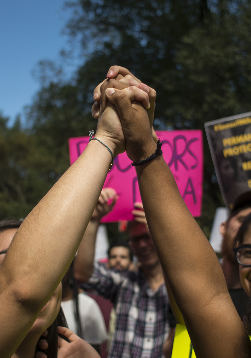 Two hands of people clasped overhead.