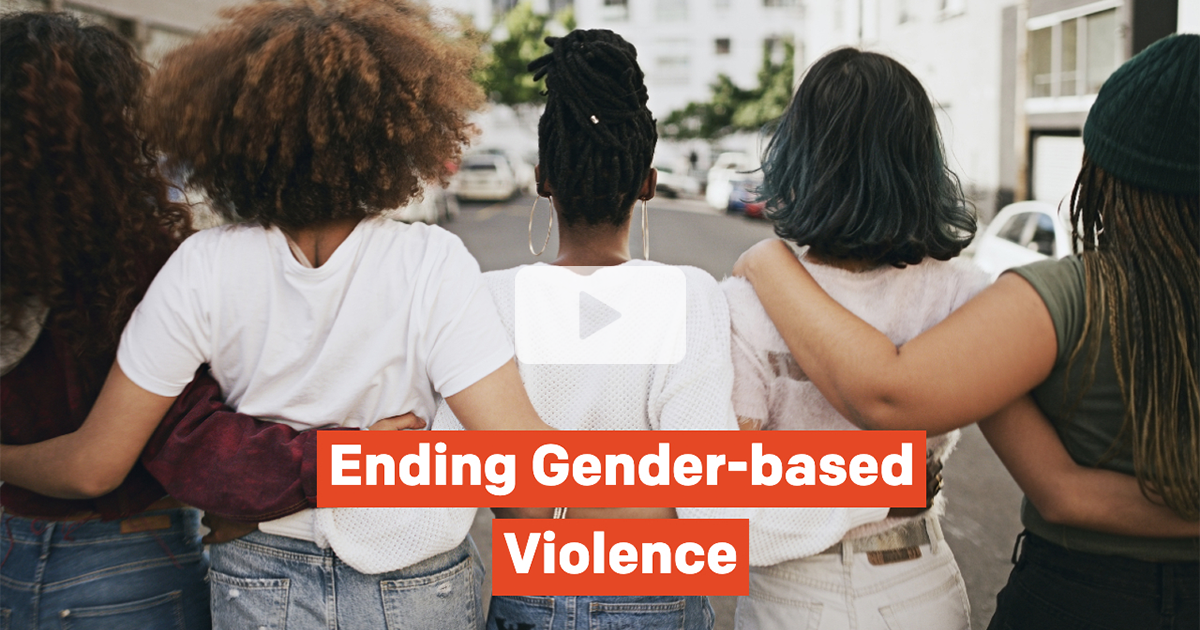 Group of women with their arms around each other's backs facing away from the camera with text that reads, "Ending Gender-based Violence" at the bottom"