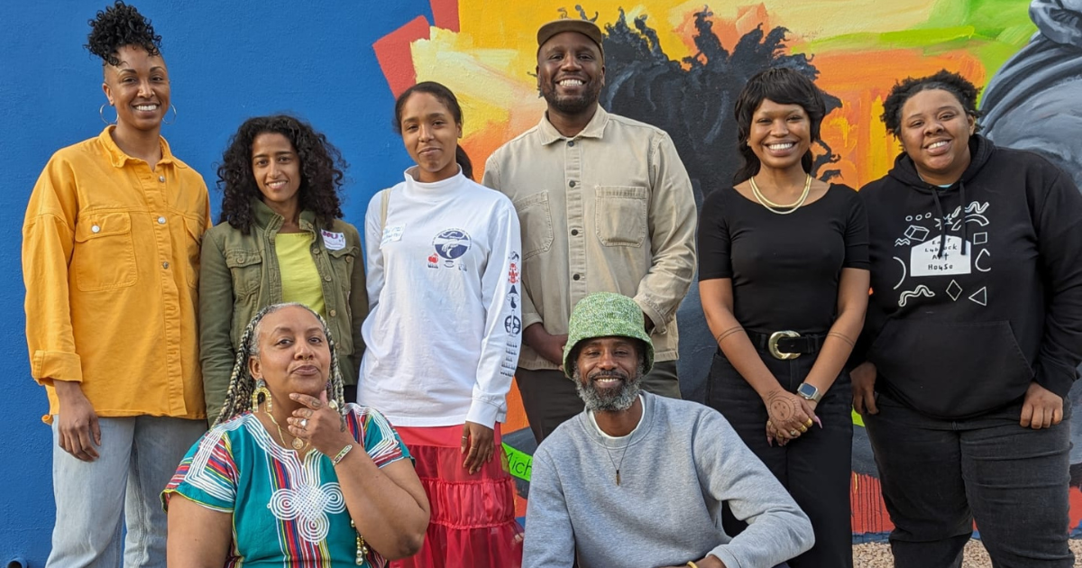 Photo of eight artist fellows: six standing; two squatting down