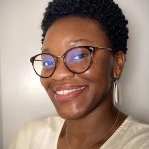 smiling black woman with natural black hair and brown eyes with glasses