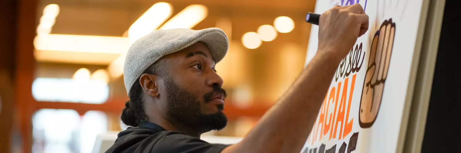 A photo of an artist drawing a mural